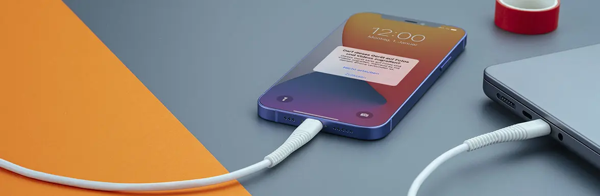 De mobiele telefoon is via een kabel met de notebook verbonden.