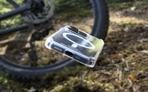 Le smartphone dans une coque de téléphone mobile tombe du vélo sur le sol de la forêt.